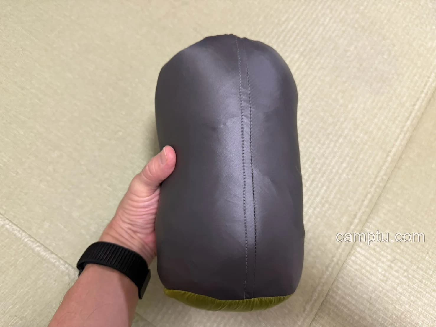収納袋に入れたサーマルシーツを手に持ったところ。持ち運ぶときのサイズ感が分かります。